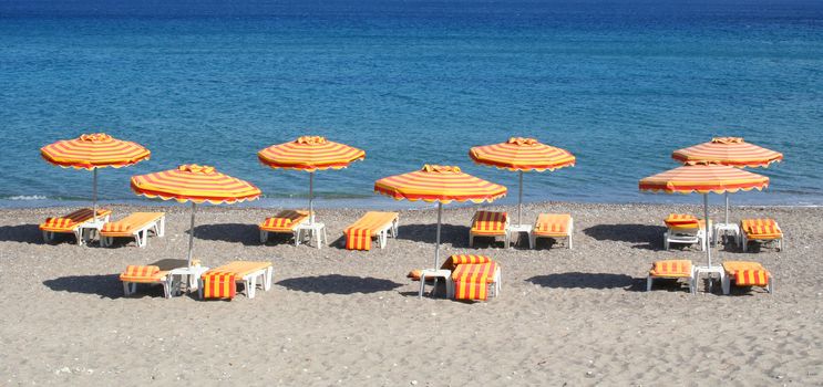 Greece. Kos island. Kefalos beach. Orange chairs and umbrellas on the beach 