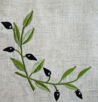 Embroidery of olive branch on linen beige fabric can use as background 