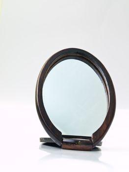 A wooden pocket makeup mirror isolated on white background