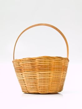 A yellow wicker basket isolated on white background