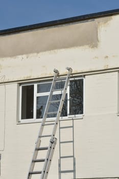 Ladder leaning against wall with window