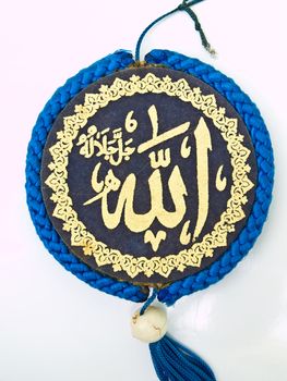 Close up of blue velvet Allah pendent isolated on white background