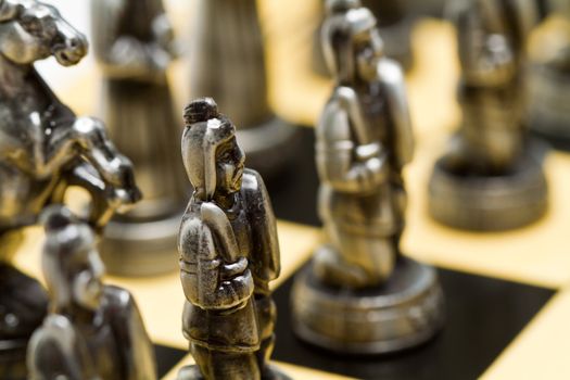 close up of a silver chess pieces on a checkerboard