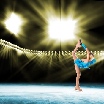 young skater performs on the ice in the background lights lighting