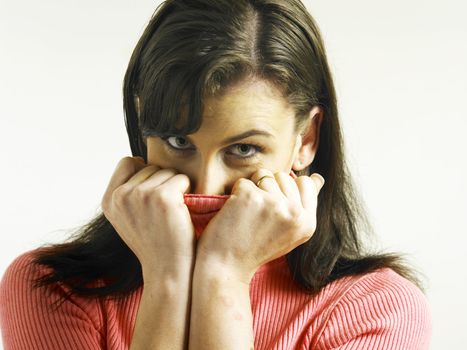 Woman covering face with turtleneck looking at the camera