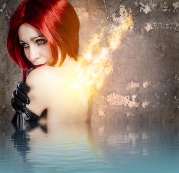 Red-haired woman with back fire on water effect