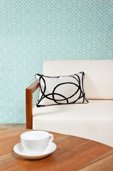 Bright white furniture in a living room with turquoise blue wallpaper