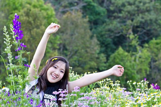 Asian woman relaxing in the flowers garden