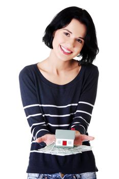 Happy woman holding polish zloty bills and house model over white - real estate loan concept