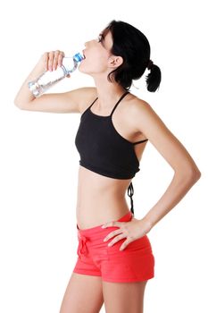 Young fit woman drinking mineral water after fitness exercise