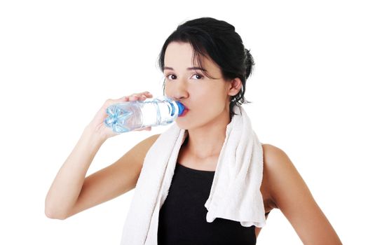 Young fit woman drinking mineral water after fitness exercise