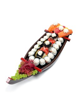 Set of sushi on wooden stand in the form of the boat isolated on white