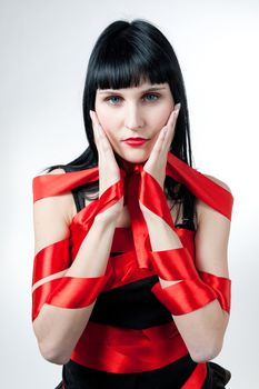 Sexy women in black dress rolled up by a red ribbon