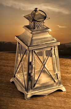 Old lantern in sunset light over a wooden table