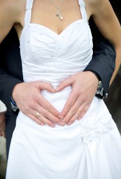 Wedding couple showing heart with their hands