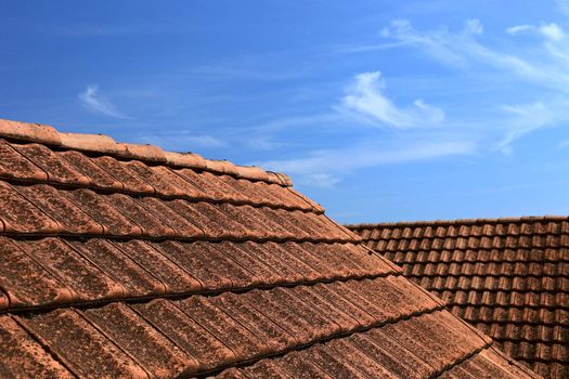 Old tiled roof and beautiful blue sky. Abstract photo as background or backdrop.