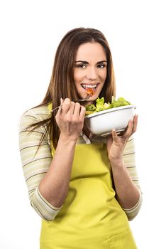 Young Woman Cooking and eating healthy Food - Vegetable Salad. Diet. Dieting Concept. Healthy Lifestyle. Cooking At Home. Prepare Food 