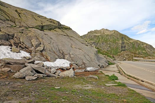 Road through swiss Alps in Summer. There is still some snow.