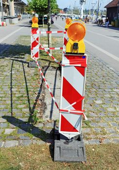 Road signs with flashers informing about some danger during pavement repair, Switzerland.