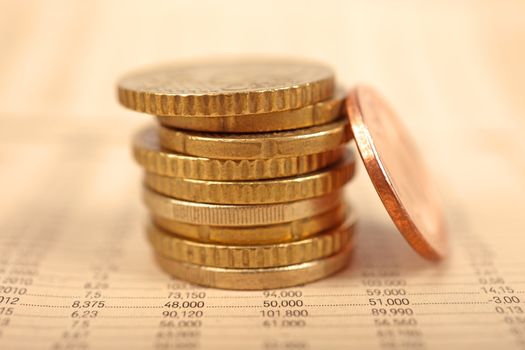 Macro of euro coins and financial newspaper.