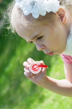 Little cute girl blow bubbles, outdoor shoting