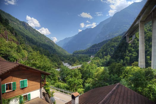 Modern alpine valley  with highway and railroad in Switzerland, Europe.
