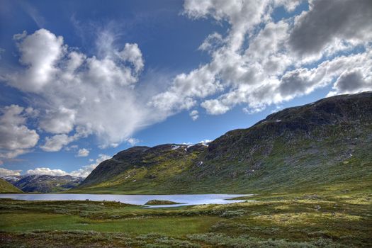 Picturesque norwegian landscape with small lake and green hills, scandinavian Europe.