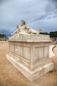 Sculpture in Tuileries gardens and dramatic sky in background, Paris, France.