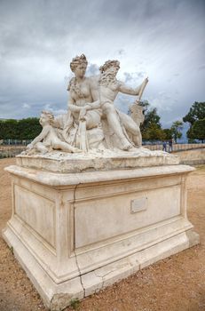 Sculpture in Tuileries gardens and dramatic sky in background, Paris, France.