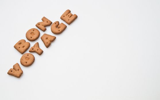 the phrase bon voyage made by brown biscuits arranged slanting on white surface