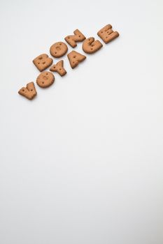 the phrase bon voyage made by brown biscuits slanting arrangement on white surface portrait orientation