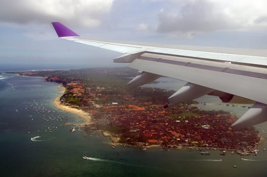 Plane flying over Bali before landing.