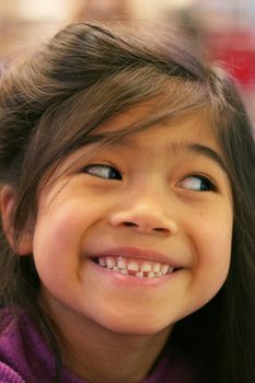 Seven year old girl proudly showing her loose tooth.