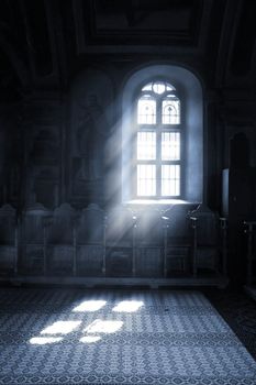 Shafts of light stream through stained glass window inside a church
