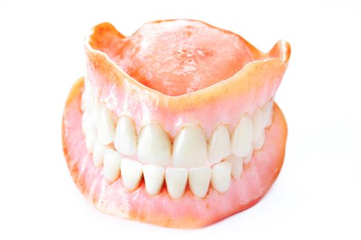 Dentures that need cleaning isolated on a white background.