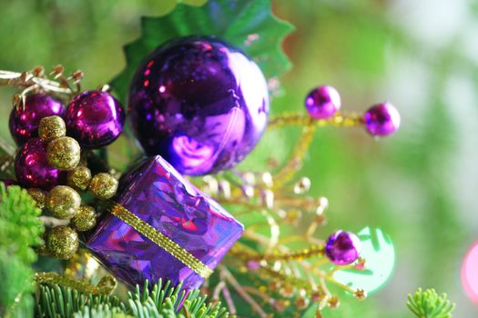 Purple present ornament nestled in CHristmas tree.