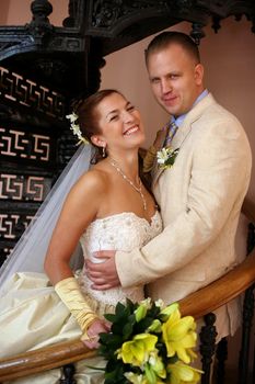 The beautiful bride and groom on a pig-iron ladder