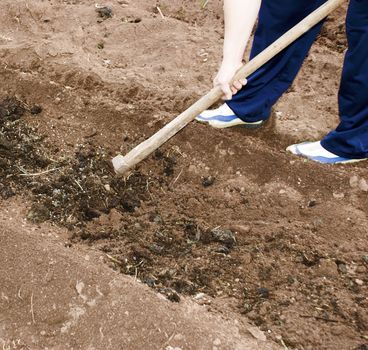 a woman is digging a soil to prepare it for seeding