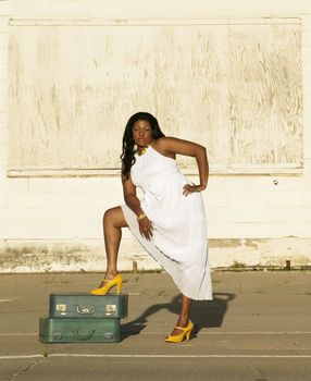 African American woman showing her leg along the side of a road.