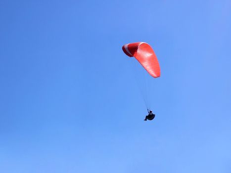 Paraglider flying over us in the blue sky