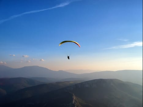 a paraglider is flying in a twilight
