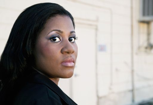 African America business woman in front of an industrial building.