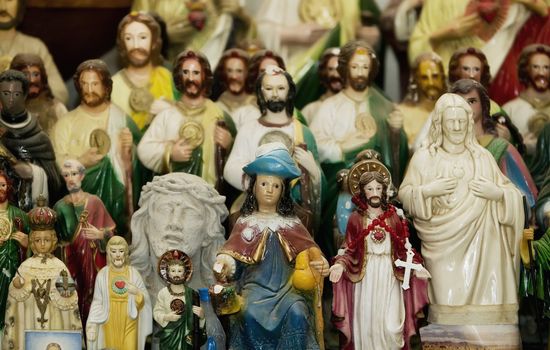 Many statues of jesus Christ and saints on a Hsipanic Catholic altar.