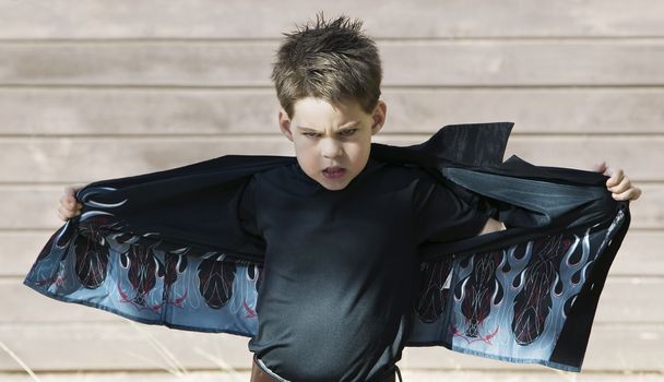 Young boy with his shirt stretched out like wings