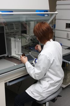 scientist working with chemicals and equipment in a real life pharmaceuticals laboratory