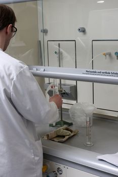 scientist working with chemicals and equipment in a real life pharmaceuticals laboratory