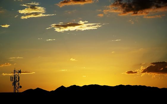 Wide shot of sunset with a telecommunications tower bottom left.