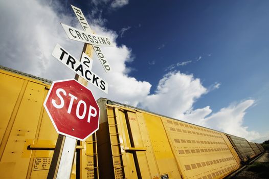 Train stopped at a crossing with a dramatic sky.