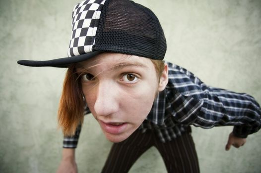 Wide angle shot of a teenage in front of a green stucco wall