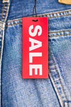 Red Sale Sign With Jeans in Background